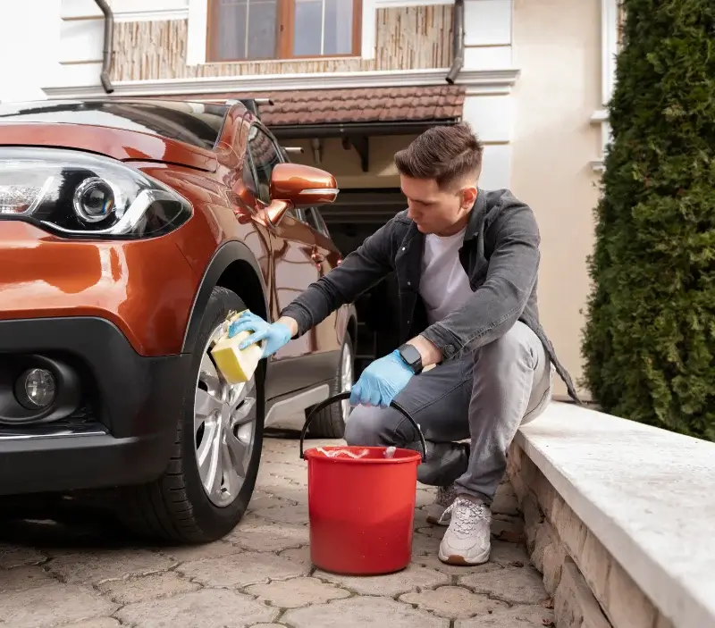 Lavage auto à domicile Merles : professionnel intervenant sur un véhicule